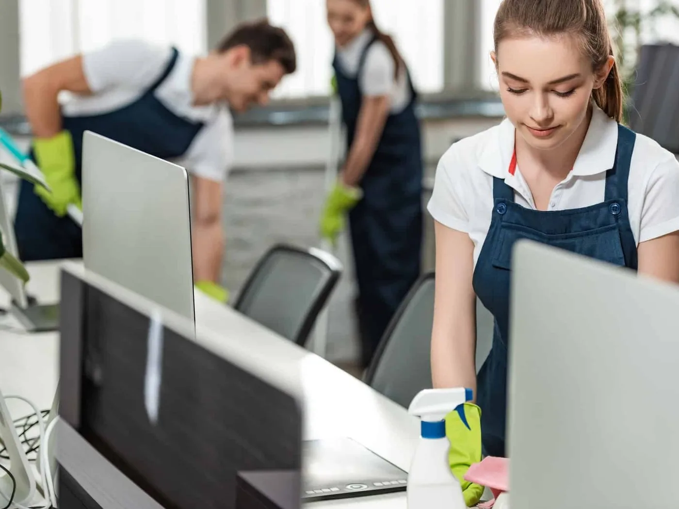 Cleaners working through the desks of an open-plan office